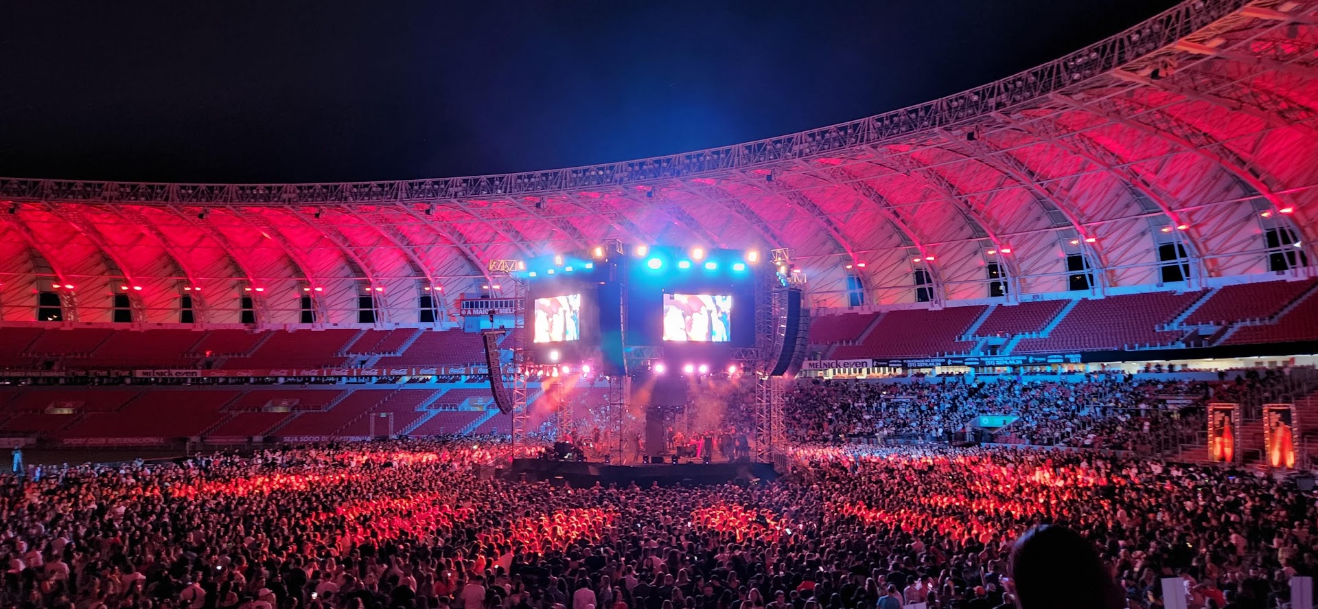 Arena iluminada em vermelho durante o show